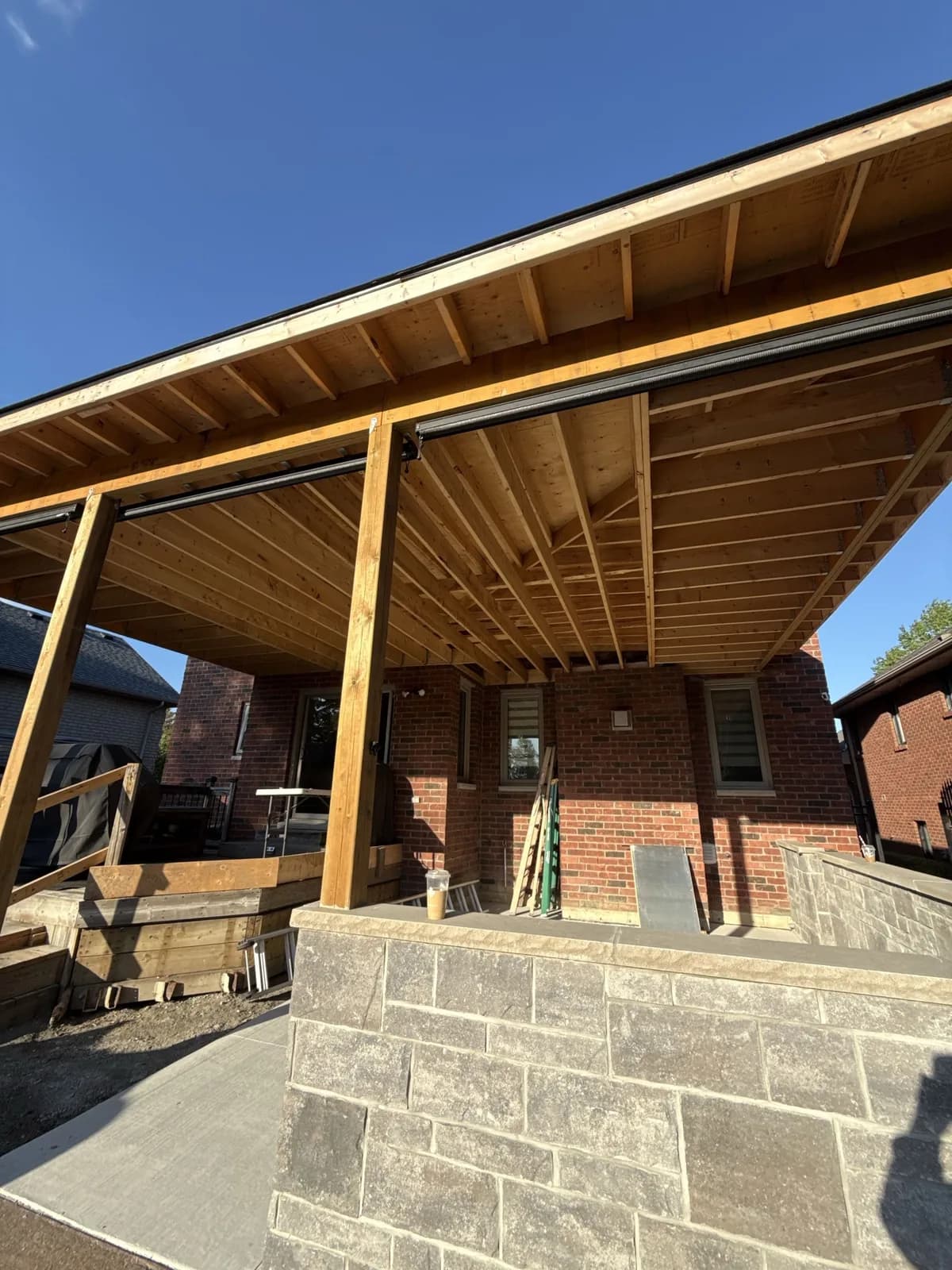 Exposed timber framing beneath a covered roof extension